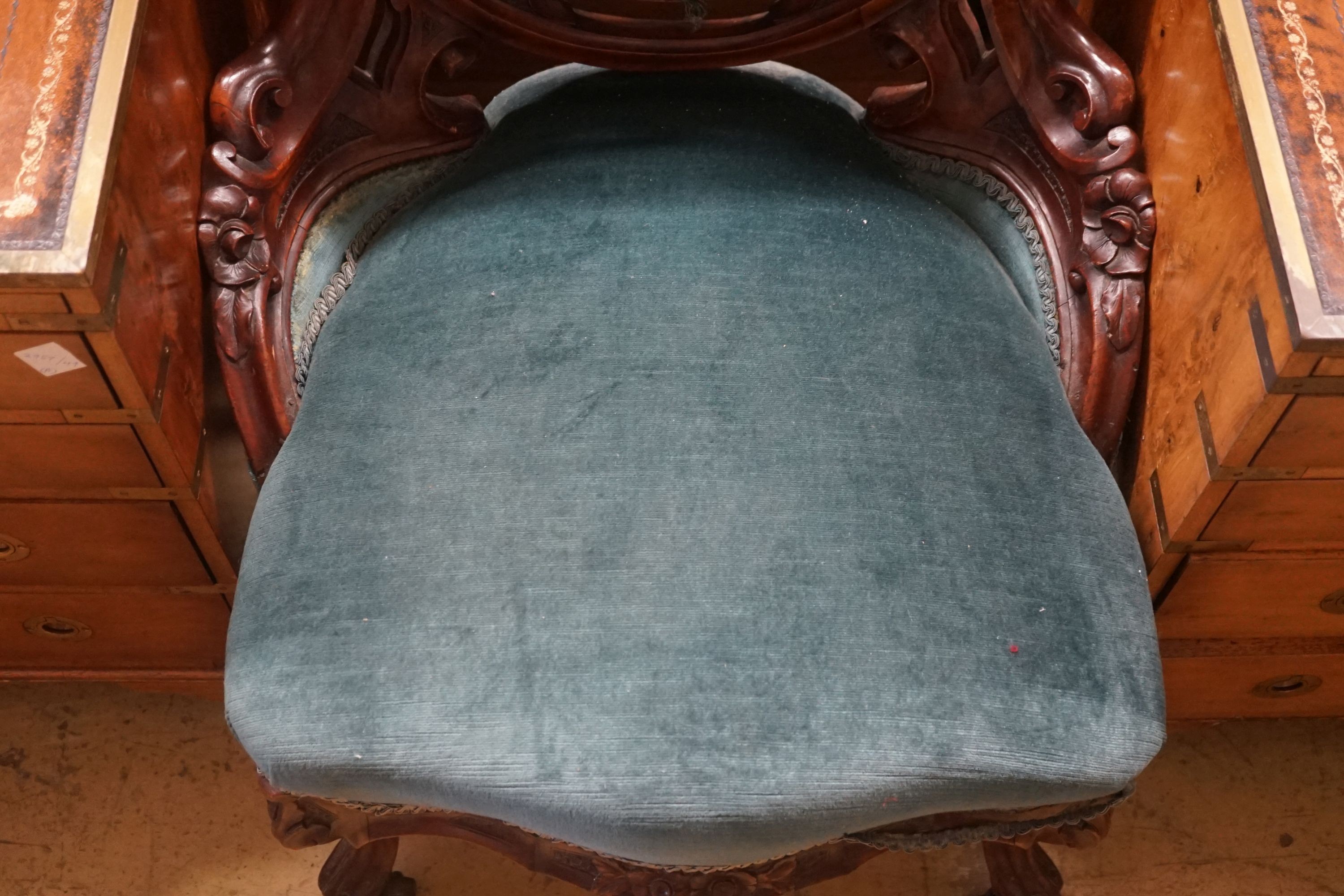 A Victorian carved mahogany spoon back salon chair with buttoned blue upholstery